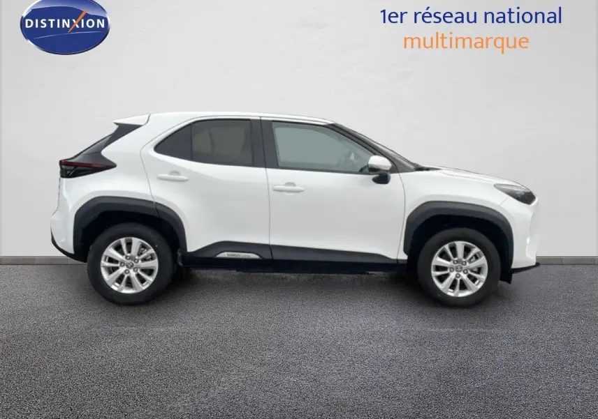 Profil droit d'une Toyota Yaris Cross hybride blanche 2024 avec protections noires sur les passages de roues.