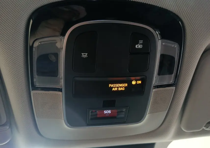 Vue intérieure du plafonnier du Hyundai Tucson gris foncé 2025, avec indicateur airbag passager et bouton SOS.
