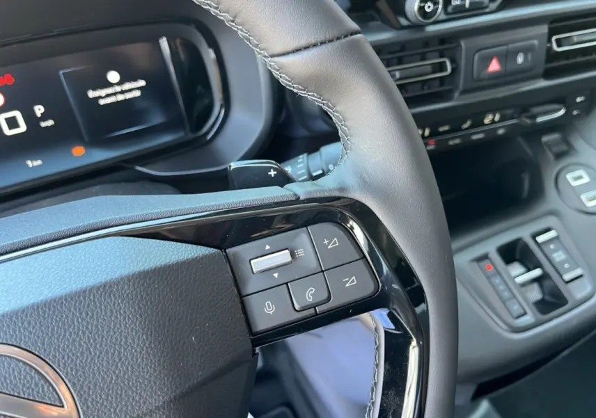 Gros plan sur le volant cuir multifonctions et tableau de bord numérique du Citroën Berlingo BlueHDi 130 2025.