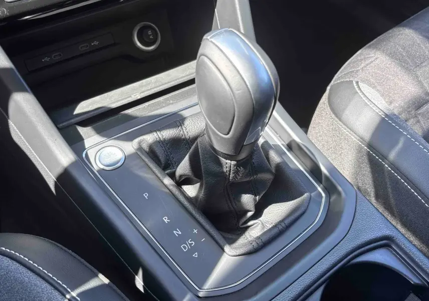 Gros plan sur la commande de boîte automatique DSG7 et le bouton Start/Stop du Volkswagen Touran blanc, intérieur noir.