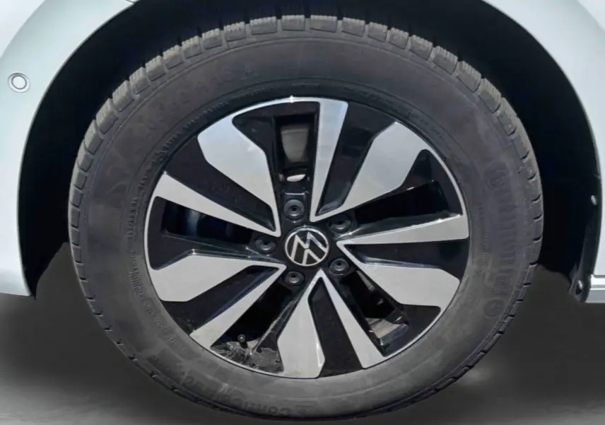 Gros plan sur la jante alliage bicolore noire et argent du côté gauche d’un Volkswagen Touran blanc.