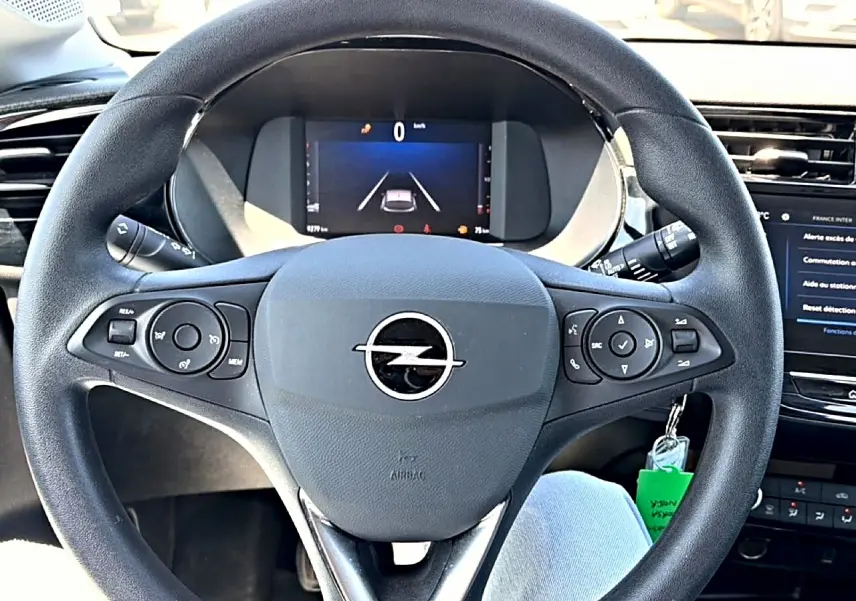 Vue rapprochée du volant noir multifonction d'une Opel Corsa 1.2 turbo 100 edition avec tableau de bord numérique.