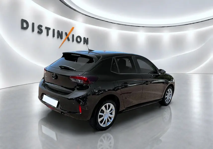 Opel Corsa 1.2 turbo noir vue 3/4 arrière droit dans un showroom lumineux avec logo Distinxion.