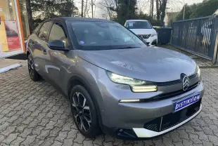 Citroën C4 gris foncé vue 3/4 avant droit avec toit noir et feux LED allumés sur parking extérieur.