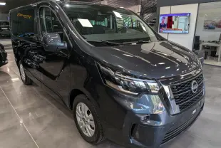 Vue 3/4 avant droit du Nissan Primastar Combi gris comète, mettant en valeur sa calandre chromée et ses phares modernes.