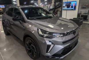 Renault Symbioz gris Cassiopé en 3/4 avant droit, mettant en valeur ses optiques LED et jantes noires brillantes.