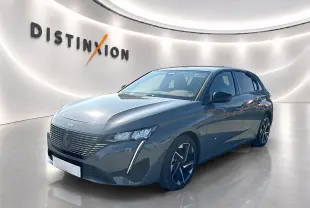 Peugeot 308 gris Artense vue 3/4 avant droit dans un showroom lumineux avec jantes alliage noires et grises.