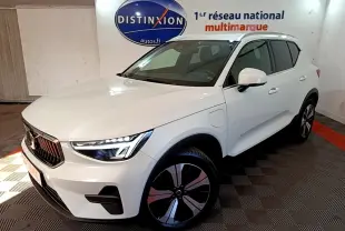 Vue 3/4 avant droit d'un Volvo XC40 hybride rechargeable blanc avec jantes noires et détails chromés.