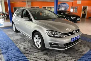 Volkswagen Golf gris vue 3/4 avant droit en intérieur, avec jantes alliage et phares LED allumés.
