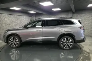 Profil côté gauche du Renault Espace 2025 gris Baltique avec jantes alliage 20 pouces et vitres surteintées.