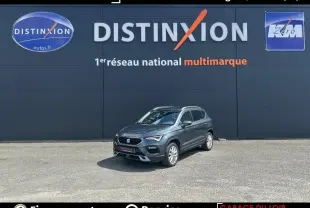 SEAT Ateca gris foncé vue 3/4 avant droit, avec calandre distinctive et barres de toit chromées.
