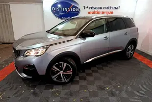 Peugeot 5008 gris clair vue 3/4 avant droit, avec jantes alliage et rétroviseurs noirs brillants.