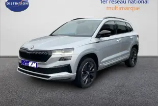 Vue 3/4 avant d’un Skoda Karoq gris argent métallisé avec jantes noires et calandre noire sportive.