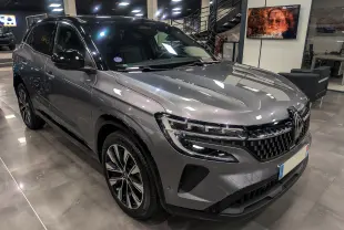 Renault Austral gris schiste avec toit noir, vue 3/4 avant en intérieur, mettant en valeur sa calandre et ses jantes biton.