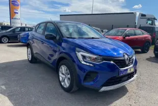 Renault Captur Evolution Mild Hybrid 140 EDC bleu Iron vu en 3/4 avant sur parking extérieur avec plaque Zero KM.