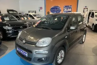Vue 3/4 avant droite d'une Fiat Panda gris colosseo métal exposée en showroom avec plaques Distinxion visibles.