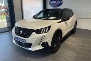 Peugeot 2008 blanc vue 3/4 avant droit en intérieur avec calandre noire et jantes foncées.
