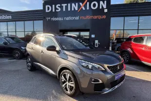 Peugeot 3008 gris métal en 3/4 avant droit, avec jantes alliage et calandre distinctive GT Line devant un showroom Distinxion.