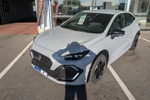 Vue 3/4 avant droit d'une Renault Clio VI TCE 115ch Techno gris Rafale métal avec jantes noires et détails noirs contrastants.