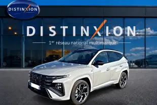 Hyundai Tucson 2026 gris shadow en 3/4 avant droit devant showroom Distinxion, jantes alu noires et toit noir.
