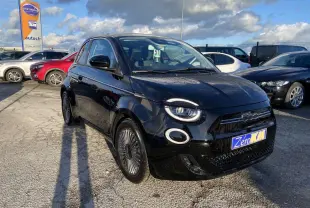 Fiat 500 électrique noire vue 3/4 avant droit, avec jantes stylisées et toit vitré panoramique visible.