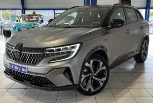 Renault Austral gris 3/4 avant droit en showroom, avec calandre damier ice black et jantes alliage 20 pouces.