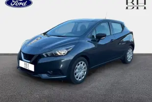 Nissan Micra 1.0 71ch Visia Pack gris acier vue 3/4 avant droit avec jantes enjoliveurs et feux halogènes allumés.