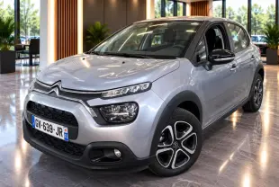 Citroën C3 gris foncé vue 3/4 avant droit en intérieur, avec jantes alliage et détails noirs contrastants.