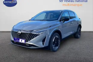 Vue 3/4 avant droit du Nissan Qashqai 2025 gris argile métal avec calandre noire et jantes bicolores.