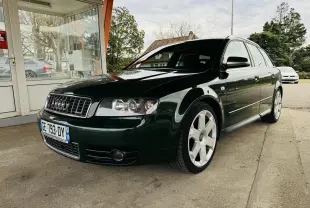 Audi S4 Avant vert foncé vue 3/4 avant droit, jantes alliage et calandre chromée sous un abri.