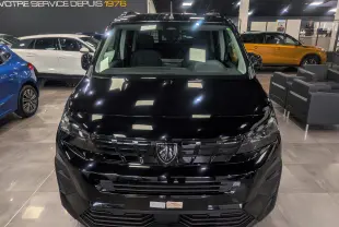 Vue de face d’un Peugeot Rifter noir 2025 dans un showroom, mettant en valeur sa calandre et ses phares modernes.