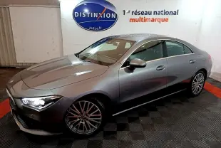 Vue 3/4 avant droit d'une Mercedes CLA 180 d Business Line gris clair avec jantes alliage et phares allumés en intérieur.