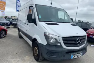 Vue 3/4 avant d'un Mercedes Sprinter blanc de 2015 avec pare-chocs noir et plaques françaises sur parking.