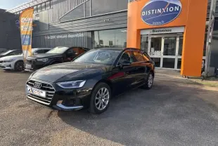 Audi A4 Avant noir brillant vue 3/4 avant droit, stationnée devant un garage avec enseigne orange Distinxion.