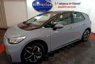 Vue 3/4 avant droit d'une Volkswagen ID.3 77 kWh Pro S gris foncé en intérieur, avec jantes distinctives et logo visible.