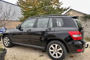 Mercedes GLK 220 CDI noir vu de profil côté gauche, avec barres de toit et jantes alliage visibles
