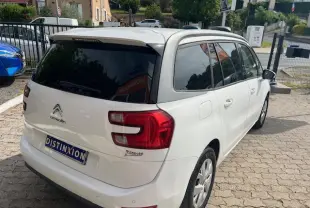 Vue 3/4 arrière droite d'un Citroën Grand C4 Picasso blanc avec vitres surteintées et jantes alliage 16 pouces.