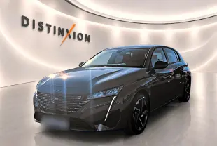 Vue 3/4 avant droite d'une Peugeot 308 gris selenium avec phares LED et jantes alliage noires dans un showroom lumineux.