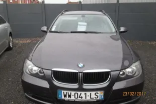 Vue avant d'une BMW Série 3 Touring E30 gris foncé avec calandre double haricot et plaque d'immatriculation française visible.
