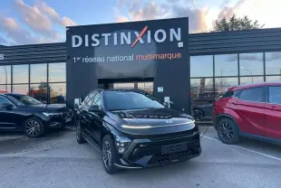 Vue 3/4 avant d'un Hyundai KONA II noir Abyss Metal avec jantes alliage et calandre marquée N Line, stationné devant un bâtiment Distinxion.