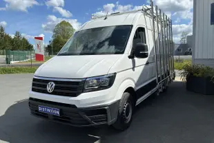 Volkswagen Crafter blanc vu en 3/4 avant droit avec porte-échelles latéral et calandre noire.