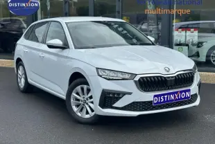 Skoda Scala blanc cristal vue 3/4 avant droit, calandre noire et jantes alu visibles sur parking.