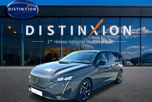 Peugeot 308 gris selenium vue 3/4 avant droit, avec calandre distinctive et jantes alliage noires.