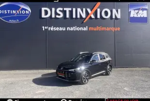 MG Motor ZS noir en 3/4 avant droit, stationné devant un mur gris avec logo Distinxion.