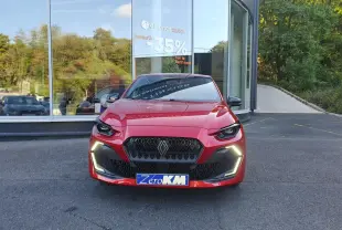Renault Clio VI rouge absolu vue de face, avec signature lumineuse LED en forme de C et calandre noire hexagonale.