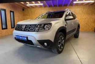 Dacia Duster gris vue 3/4 avant droit en intérieur, avec calandre noire et jantes alliage 17 pouces Maldives.