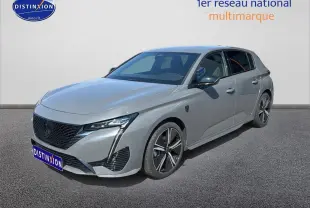 Peugeot 308 gris vue 3/4 avant droit, avec jantes alu et calandre noire distinctive.