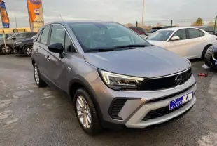 Opel Crossland gris alu en 3/4 avant droit, avec coques de rétroviseurs noires et jantes alliage 16 pouces.