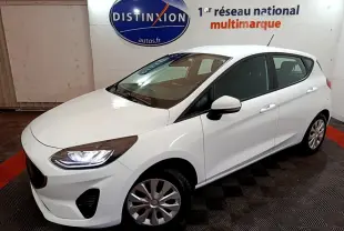 Vue 3/4 avant droite d'une Ford Fiesta blanche 2022 avec phares LED et jantes alliage dans un showroom.