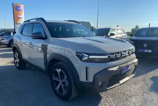 SUV Dacia Duster 2025 beige Sandstone vu en 3/4 avant droit avec calandre distinctive et jantes noires.